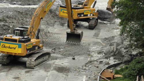 Bagger räumen Felsen und Geröll auf der neuen Kantonsstrasse weg