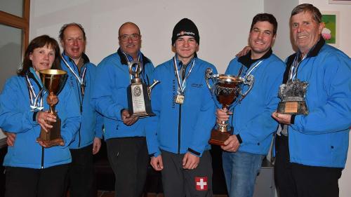 Alle Wandertrophäen der Eisstock-Bündnermeisterschaft bleiben in Sur En. Von links: Erica Koch, Jon Curdin Cantieni, Otto Davaz, Orlando Bass, Claudio Mathieu und Giacinto Mayer (Foto: Nicolo Bass).