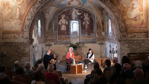 Elena Wullschleger (a schnestra) e Nina Dazzi haun prelet illa chapella da San Bastiaun poesias dad Irma Klainguti.  (fotografia: Lia Rumantscha/Mayk Wendt)