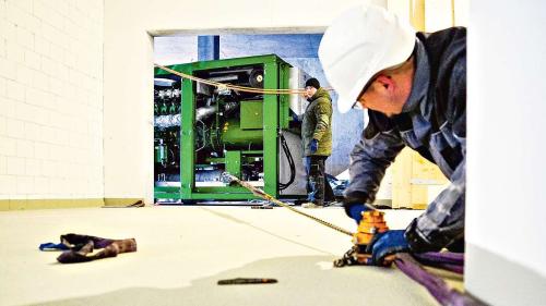 Es brauchte Muskelkraft und auch etwas Improvisationstalent, um das acht Tonnen schwere Blockheizkraftwerk in der ARA Oberengadin an seinen Standort zu bekommen. Foto: Jon Duschletta