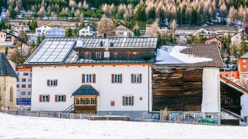 Südansicht des Hauses Schucan in Zuoz mit unterschiedlichen Dachmaterialien, thermischer Solaranlage, Küchenlaube aus den 1940er- und Dachgaube aus den 1960er-Jahren sowie dem Heustall, der zu Erstwohnungen umgebaut werden soll. Das Stalldach soll eine 