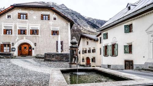 Das brachliegende Gasthaus Crusch Alba (links) im Dorfzentrum von Lavin hat schon bessere Tage erlebt. An diese Zeiten soll nun angeknüpft werden und dem Haus neues Leben eingehaucht werden. Foto: Jon Duschletta