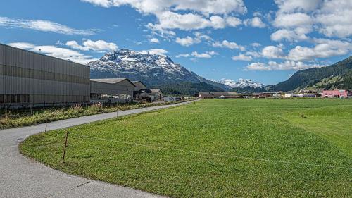 Blick auf Cho d’Punt mit Gebäuden des Flugplatzes (links). Die Wiese rechts könnte eine Option für die Erweiterung der Gewerbezone Cho d’Punt sein. 	Foto: Daniel Zaugg