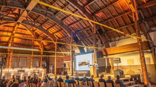 Nur gut 50 Personen wollten am Dienstagabend die Infoveranstaltung vor Ort in der Reithalle mitverfolgen. Rechts das Modell der wieder stützenfreien Reithalle nach der Sanierung. Foto: Reto Stifel, Visualisierung Gemeinde St. Moritz 