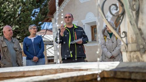 Gisep Derungs, il maister da bügls da Scuol, declera als giasts cha l’aua minerala cuorra adüna da la vart dretta. Tanteraint quinta’l anecdotas (fotografias: Dominik Täuber e Selina Bisaz).