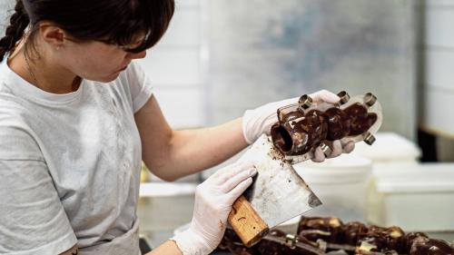 Bei der Schokomasse ist die richtige Temperatur wichtig. Handarbeit beim Abfüllen und Fingerspitzengefühl beim Schminken.	Fotos: Daniel Zaugg