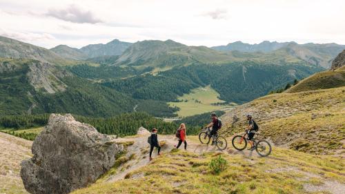 Viandants e bikers i’l Parc da natüra Biosfera Val Müstair chi piglian resguard l’ün a l’oter (fotografia: Doyenne).