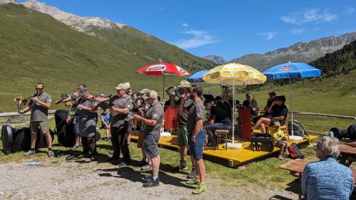 Ils Cornists da Scuol in acziun sün l’Alp Astras-Tamangur in S-charl,  davovart la Chapella Blazenka (fotografia: Peder Rauch).