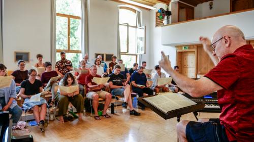 Dirigent Stefan Albrecht übt mit der Engadiner Kantorei in der Aula der Academia Engiadina in Samedan. Fotos: Jon Duschletta 