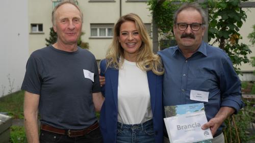 Ils rapreschantants dals cumüns da Scuol e Valsot, Fadri Blanke (a schnestra) e Victor Peer, insembel cun Christa Rigozzi in occasiun da la festa in marcurdi passà a Turich (fotografia: mad).