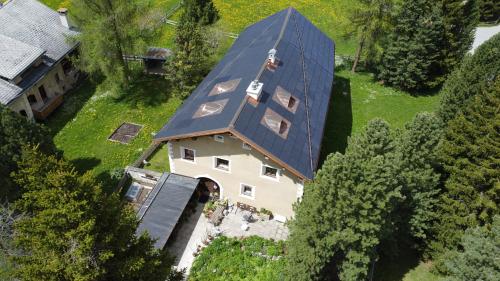 Erst aus der Luft wird die Komplexität der integrierten PV-Anlage auf dem PlusEnergieHaus von Reto und Eva Kienast-Wagner in La Punt Chamues-ch richtig ersichtlich. Foto: Carlo Vassella