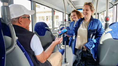 Die Teamleiterin Marketing der Bus und Service AG, Anja Arnold (rechts), hat am Dienstag zusammen mit Barbara Laim und anderen Mitarbeitenden Jubiläumsgeschenke an die Fahrgäste von Engadin Bus verteilt. Fotos: Jon Duschletta