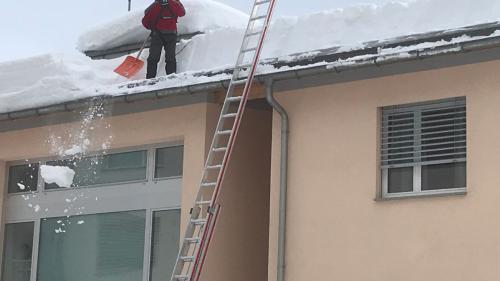 Profis befreien ein Dach vom Schnee. Foto: Reto Stifel