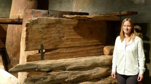 Monika Oberhänsli, Mitarbeiterin des Archäologischen Dienstes Graubünden und Autorin des neuen Buches, vor der bronzezeitlichen Quellfassung im Paracelsusgebäude in St. Moritz. Foto: z.Vfg